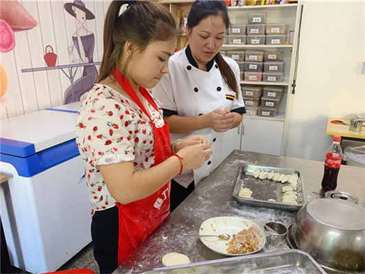 魅力小吃培訓學校現(xiàn)場教女學員餃子制作